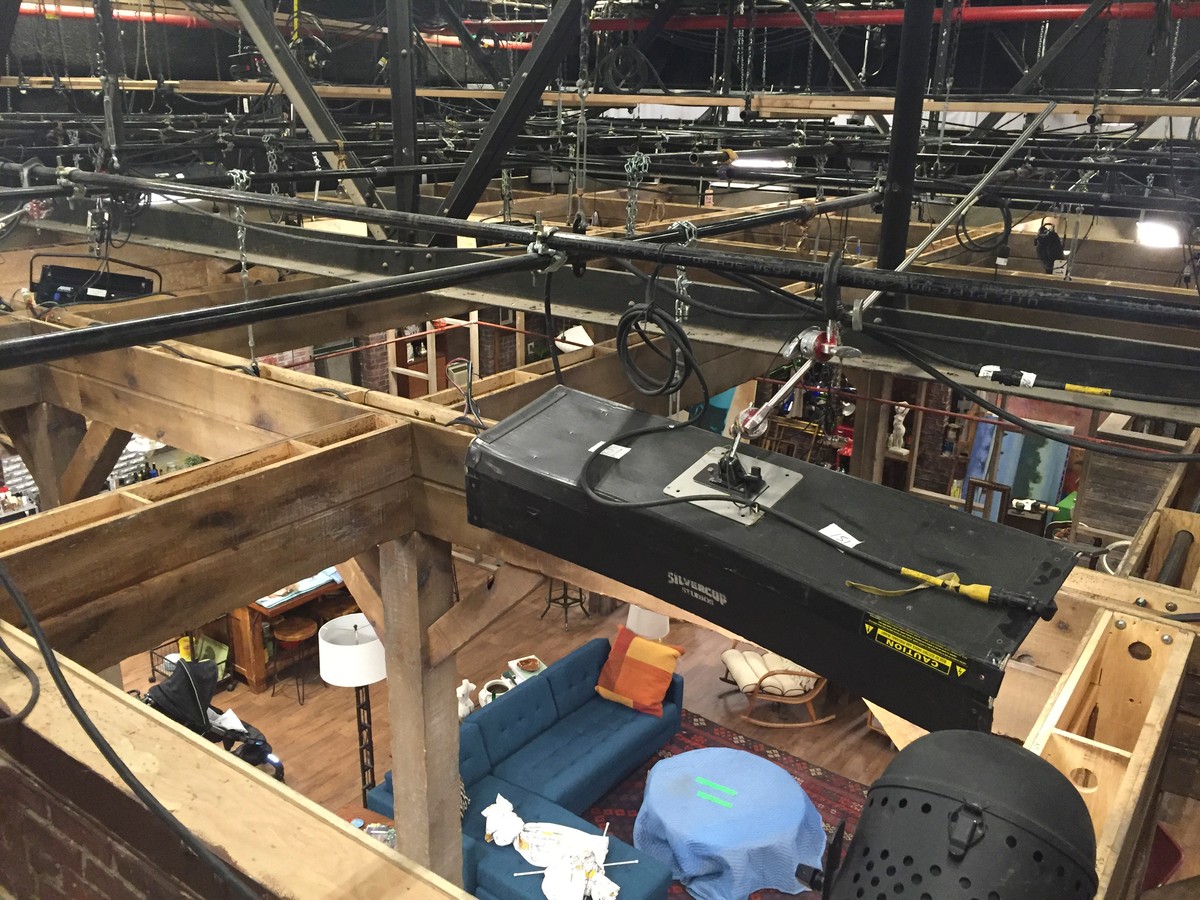 Overhead view of stage rigging at Silvercup Classic during Season Seven prep — wooden set framing visible against the grid trusses