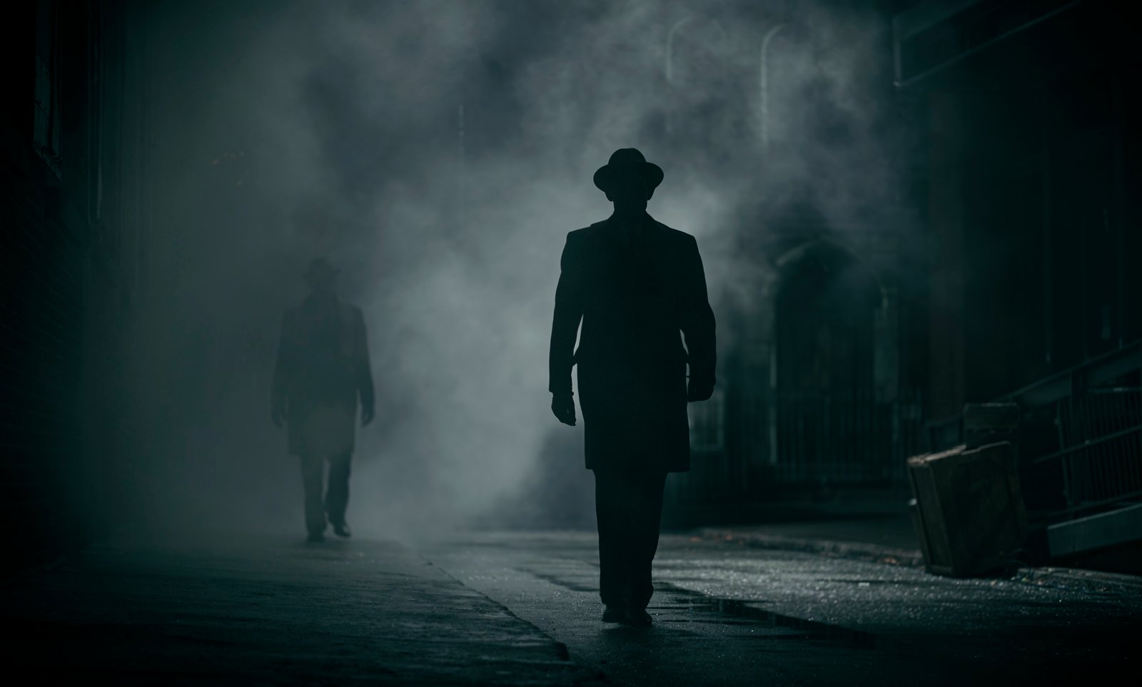 Silhouetted figure in fedora on a fog-filled night street — Wormwood